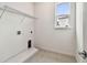 The laundry room features tile flooring, utility connections, and a window for natural light at 13715 Brookside Haven St, Riverview, FL 33578