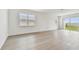 Bright, airy living room with hardwood floors and sliding glass doors to the backyard at 13715 Brookside Haven St, Riverview, FL 33578