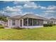 Rear view of house showcasing a screened porch and lawn at 657 Masterpiece Dr # 154, Sun City Center, FL 33573