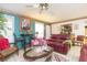 Living room with a red leather couch and ceiling fan at 6515 Los Altos Way, Tampa, FL 33634