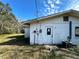 Exterior view of a simple stucco home with a side entrance at 17025 Dalberg Dr, Spring Hill, FL 34610