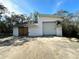 White garage with roll-up and wooden doors, needs some repairs at 17025 Dalberg Dr, Spring Hill, FL 34610