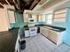Kitchen with white cabinets and teal countertops needing updates at 17025 Dalberg Dr, Spring Hill, FL 34610