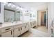 Bathroom boasts a large vanity with double sinks and a mirrored medicine cabinet at 1450 Heather Ridge Blvd # 107, Dunedin, FL 34698