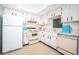 Retro kitchen features white cabinets, and classic appliances at 1450 Heather Ridge Blvd # 107, Dunedin, FL 34698