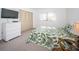 Bedroom with leafy print bedspread and a window overlooking trees at 1450 Heather Ridge Blvd # 107, Dunedin, FL 34698