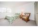 Bedroom with leafy print bedspread and wicker chair at 1450 Heather Ridge Blvd # 107, Dunedin, FL 34698