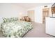 Spacious bedroom with a leafy print bedspread and ample closet space at 1450 Heather Ridge Blvd # 107, Dunedin, FL 34698