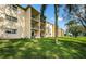 Building exterior with balconies and lush landscaping at 1450 Heather Ridge Blvd # 107, Dunedin, FL 34698