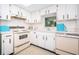 Retro kitchen features white cabinets, and classic appliances at 1450 Heather Ridge Blvd # 107, Dunedin, FL 34698