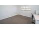 Simple bedroom with carpeted floor, window, and workspace at 1450 Heather Ridge Blvd # 107, Dunedin, FL 34698