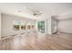 Sunlit living room with hardwood floors, sliding doors to patio, and ceiling fan at 4807 Lago Vista Cir, Land O Lakes, FL 34639