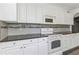 White kitchen cabinets, granite countertops, and stainless steel appliances at 906 Jurgens St, Clearwater, FL 33755