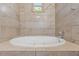Soaking tub with tile surround in updated bathroom at 906 Jurgens St, Clearwater, FL 33755