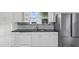 Kitchen boasts white cabinets, granite countertops, and stainless steel appliances at 906 Jurgens St, Clearwater, FL 33755