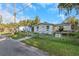House exterior showcasing a front yard, and driveway with a chain link fence at 906 Jurgens St, Clearwater, FL 33755