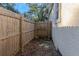 Small fenced backyard with dirt and some sparse plants at 906 Jurgens St, Clearwater, FL 33755