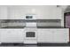 White kitchen cabinets, granite countertops and black tile floors at 906 Jurgens St, Clearwater, FL 33755