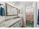 Clean bathroom with granite countertop, updated vanity, and floral shower curtain at 15212 Kestrelrise Dr, Lithia, FL 33547