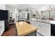 Open kitchen with white cabinets, granite countertops, and a large kitchen island with a butcher block top at 15212 Kestrelrise Dr, Lithia, FL 33547