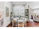 Bright dining room features a round table with four chairs, hardwood floors, and window coverings at 15212 Kestrelrise Dr, Lithia, FL 33547