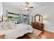 Main bedroom with a king-size bed, hardwood floors, and a view of the pool at 15212 Kestrelrise Dr, Lithia, FL 33547