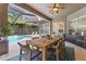 Covered patio with wooden dining table and chairs, overlooking the pool at 15212 Kestrelrise Dr, Lithia, FL 33547