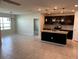 Modern kitchen with dark cabinetry, granite island, and tile floors at 918 Coastal Hammock Ave, Ruskin, FL 33570