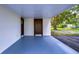 Covered porch with dark brown door and light gray flooring at 8921 Honeywell Rd, Gibsonton, FL 33534