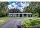 White single story home with a dark brown roof and large windows at 8921 Honeywell Rd, Gibsonton, FL 33534