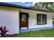 Side view of a home with dark brown door and window trim at 8921 Honeywell Rd, Gibsonton, FL 33534