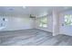 Bright living room featuring gray vinyl plank flooring and a ceiling fan at 8921 Honeywell Rd, Gibsonton, FL 33534