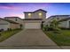 Two-story home with a white garage door and landscaped yard at 6406 Bar S Bar Trl, Zephyrhills, FL 33541