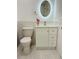 Cozy bathroom featuring a decorative lit mirror, single sink vanity, and a low-flow toilet at 11452 81St Pl, Seminole, FL 33772
