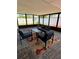 Inviting screened porch with brick flooring, modern furniture, and vibrant floral rug at 11452 81St Pl, Seminole, FL 33772