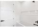 Tub and shower combination surrounded by new white tile with a shelf at 4625 W El Prado Blvd, Tampa, FL 33629