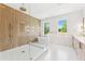 Spa-like bathroom featuring a glass-enclosed shower, a luxurious soaking tub, and elegant gold fixtures at 4625 W El Prado Blvd, Tampa, FL 33629