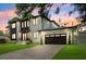 Exterior elevation of a two-story home featuring modern architecture, dark trim, manicured lawn and attached garage at 4625 W El Prado Blvd, Tampa, FL 33629