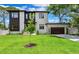 Modern two-story home with dark accents, attached garage, well-maintained lawn, and mature trees under a blue sky at 4625 W El Prado Blvd, Tampa, FL 33629
