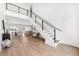 Bright foyer with modern staircase, hardwood floors, glass railing, and open floor plan looking into other living spaces at 4625 W El Prado Blvd, Tampa, FL 33629