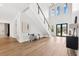 Open foyer with soaring ceilings, a modern staircase with black metal, light wood floors, and natural light at 4625 W El Prado Blvd, Tampa, FL 33629