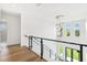 Hallway boasts wood floors, natural light from the windows, modern lighting, and a glass and iron railing at 4625 W El Prado Blvd, Tampa, FL 33629