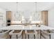 Open kitchen with island seating, modern pendant lighting, and custom cabinetry at 4625 W El Prado Blvd, Tampa, FL 33629