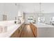 Modern kitchen with white cabinets, quartz countertops, stainless steel appliances, light wood accents, and open floor plan at 4625 W El Prado Blvd, Tampa, FL 33629