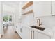 Kitchen featuring a sink, white subway tile backsplash, light wood floors, stainless steel sink and bronze fixtures at 4625 W El Prado Blvd, Tampa, FL 33629