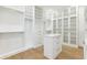 Spacious walk-in closet features custom white cabinetry, drawers, shelves and wood flooring at 4625 W El Prado Blvd, Tampa, FL 33629