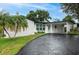 Mid-century modern home with carport and landscaping at 11452 81St Pl, Seminole, FL 33772
