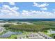 Wide aerial view of a community with townhouses and a large pond at 2166 Great Sapphire Ln, Lutz, FL 33558