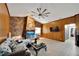Spacious living room features a stone fireplace and wood paneling at 11109 Sumner Rd, Wimauma, FL 33598