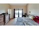 Main bedroom with king bed, dresser, and sliding doors to backyard at 11109 Sumner Rd, Wimauma, FL 33598